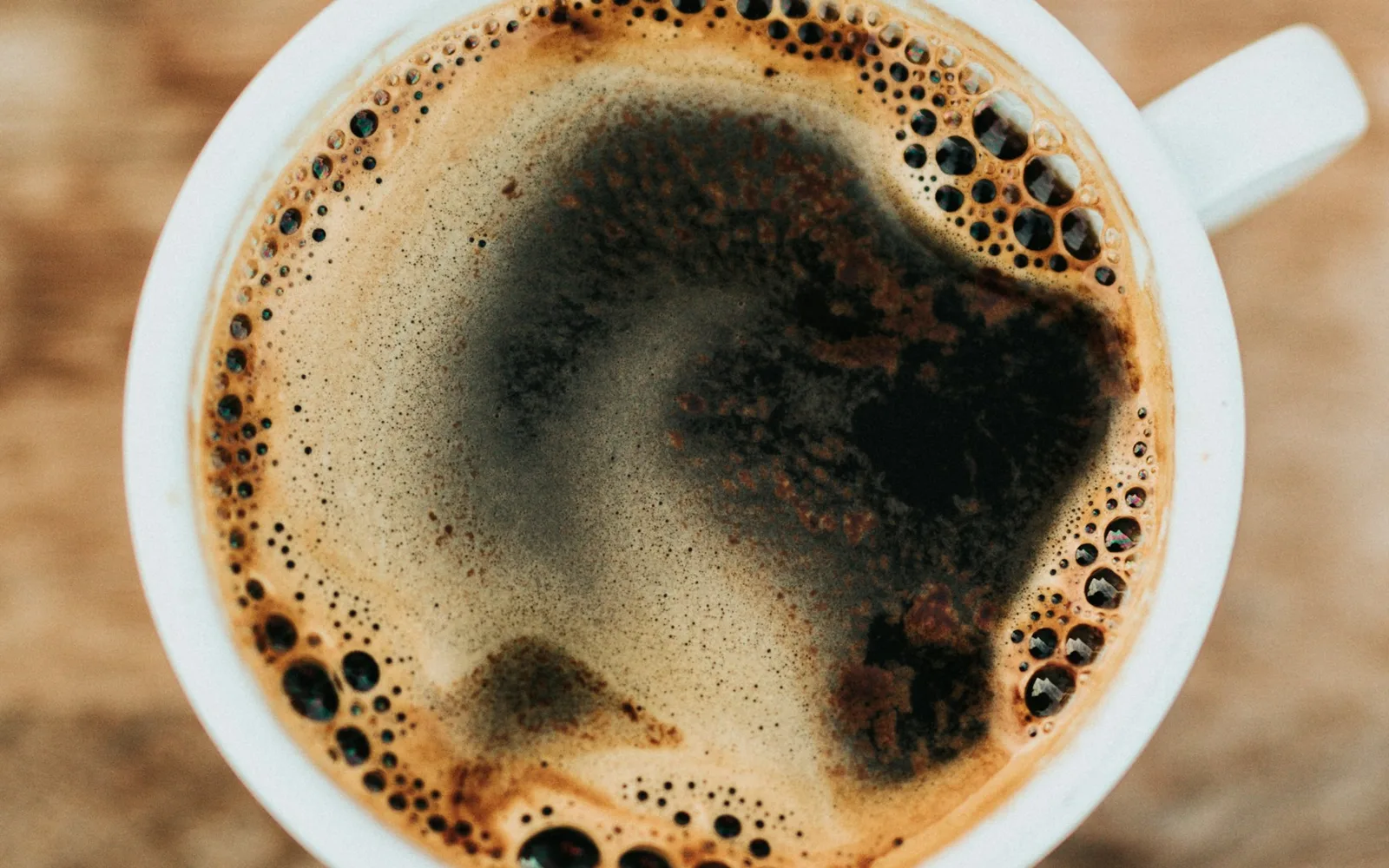 Frisch geröstete Kaffeebohnen und eine dampfende Tasse Starbucks Kaffee