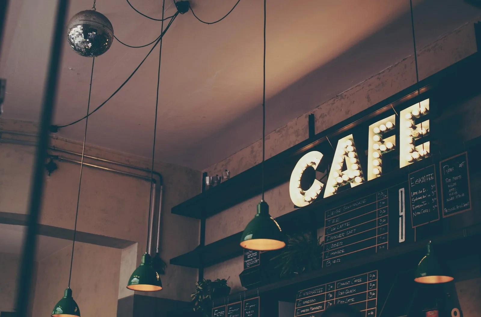 Interior de una cafetería con un letrero iluminado de café; imagen ilustrativa