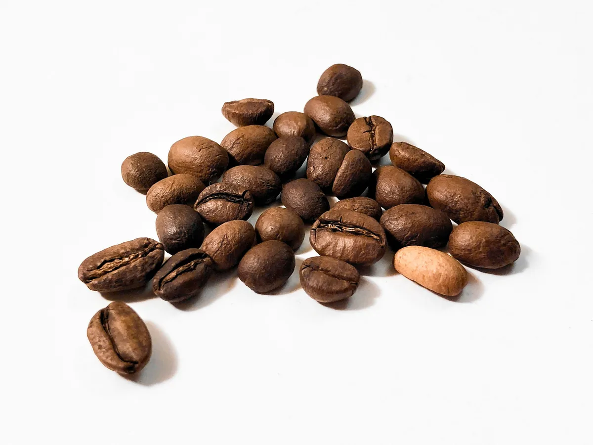 Geröstete Starbucks-Kaffeebohnen auf weißem Hintergrund